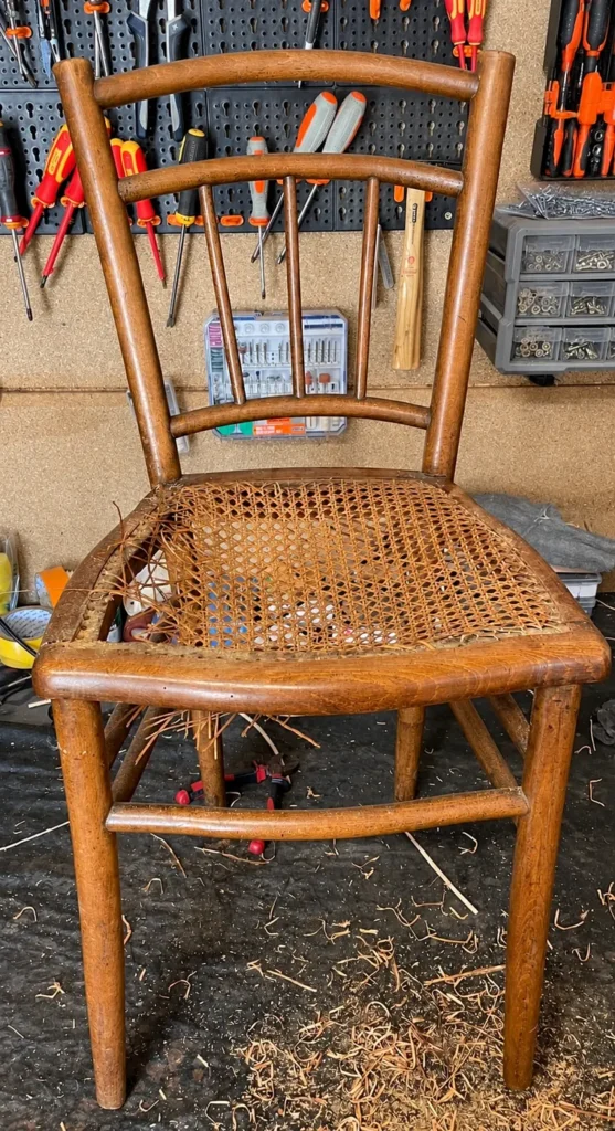 Chaise bistrot en bois au cannage déchiré, avant restauration