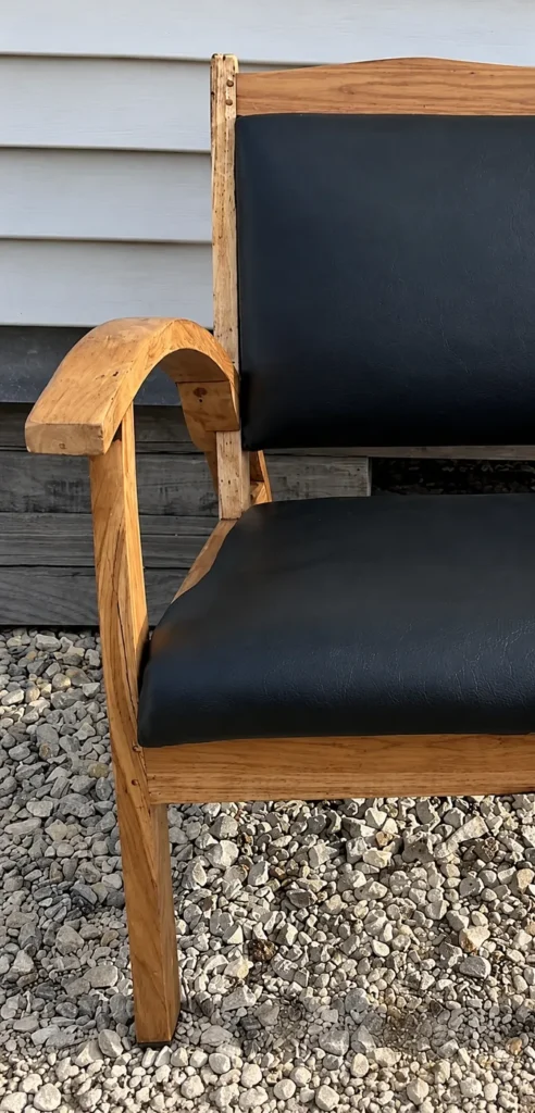 Fauteuil en chêne après restauration : bois décapé, assise et dossier refaits en noir