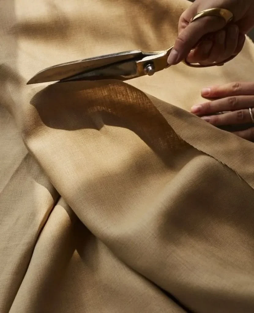 Découpe d'un tissu d'ameublement aux ciseaux de tapissier