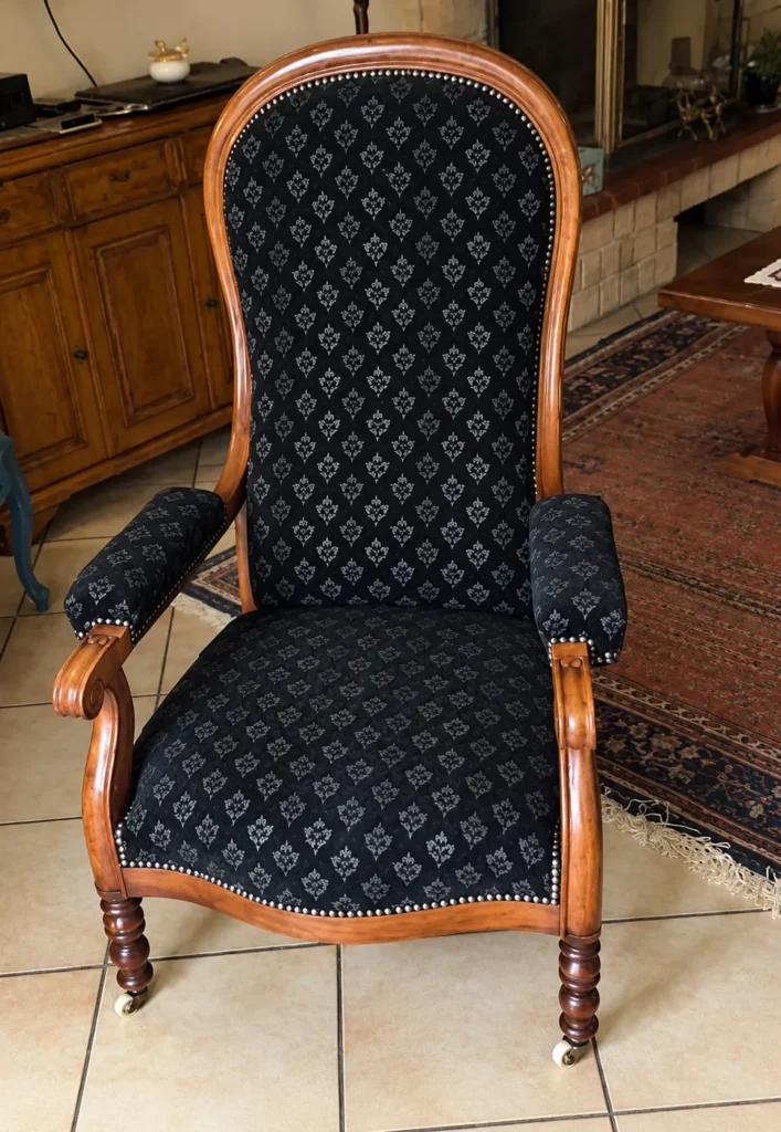 Fauteuil Voltaire après réfection complète, tissu noir à motifs et clous décoratifs